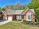 Beautiful brick home with a two-car garage, a well-kept lawn, and lovely front garden at 1670 Bookhout Dr, Cumming, GA 30041