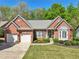 Charming brick home with manicured lawn, two-car garage, and inviting front entrance at 1670 Bookhout Dr, Cumming, GA 30041
