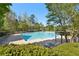 Inviting community pool featuring ample lounge chairs, mature trees, and a pergola, perfect for relaxation at 1670 Bookhout Dr, Cumming, GA 30041