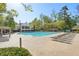 Inviting community pool featuring ample lounge chairs, mature trees, and a pergola, perfect for relaxation at 1670 Bookhout Dr, Cumming, GA 30041