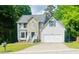 Charming two-story home with stone accents, well-maintained lawn, and attached two-car garage nestled on a wooded lot at 2317 Rocksram Ct, Buford, GA 30519