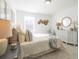 Well-lit bedroom featuring a comfy bed with decorative pillows, a dresser with decor, and neutral walls at 1715 Fulmont Cir, Mableton, GA 30126