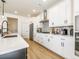 Bright kitchen with white cabinets, stainless steel appliances, quartz countertops and wood flooring at 1715 Fulmont Cir, Mableton, GA 30126