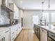 Modern kitchen features stainless steel appliances, white cabinetry, and a light wood floor at 1715 Fulmont Cir, Mableton, GA 30126