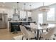 Bright, open-concept kitchen featuring white cabinetry, stainless steel appliances, a black island, and a chandelier over the dining area at 1715 Fulmont Cir, Mableton, GA 30126