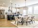 Bright, open-concept kitchen featuring white cabinetry, stainless steel appliances, a black island, and a chandelier over the dining area at 1715 Fulmont Cir, Mableton, GA 30126