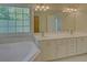 An elegant bathroom with dual sinks, granite counters, and a garden tub at 1871 Birch Briar Bnd, Lawrenceville, GA 30043
