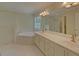 A luxurious bathroom featuring a soaking tub, a separate shower, and dual vanities with granite countertops at 1871 Birch Briar Bnd, Lawrenceville, GA 30043