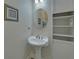 Powder room featuring a pedestal sink, decorative mirror, and convenient shelving at 1871 Birch Briar Bnd, Lawrenceville, GA 30043