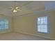Spacious bedroom with a tray ceiling, ceiling fan, two windows, and neutral carpet at 1871 Birch Briar Bnd, Lawrenceville, GA 30043