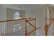 Open foyer area featuring wood railings, a hanging chandelier, and ample natural light at 1871 Birch Briar Bnd, Lawrenceville, GA 30043