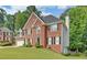 Brick two-story house featuring black shutters, green lawn, a chimney and garage with driveway at 1871 Birch Briar Bnd, Lawrenceville, GA 30043