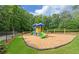 Community playground with swings, slides, benches, and a wood chip surface surrounded by a black fence at 1871 Birch Briar Bnd, Lawrenceville, GA 30043
