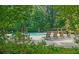 Community pool with plenty of seating and umbrellas, surrounded by luscious greenery at 1871 Birch Briar Bnd, Lawrenceville, GA 30043