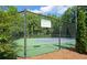 Community tennis court surrounded by woods and enclosed by a black chain link fence at 1871 Birch Briar Bnd, Lawrenceville, GA 30043