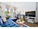 A living area with modern decor, plush blue couch, and bright natural light from the windows at 24 Becker Nw Pl, Atlanta, GA 30307