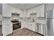 An open-concept kitchen showcases bright white cabinets, stainless appliances, and hardwood flooring at 2531 Ridgecrest Nw Dr, Kennesaw, GA 30152