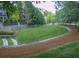 Beautiful backyard with a spacious green lawn, defined by a stone retaining wall and lush trees for added privacy at 4140 Hillside Nw Pl, Atlanta, GA 30342