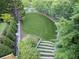Expansive backyard featuring lush green lawn, decorative retaining wall, and stone steps, offering a private outdoor space at 4140 Hillside Nw Pl, Atlanta, GA 30342
