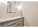 Beautiful powder room with a marble countertop, framed mirror, and decorative sconces at 4140 Hillside Nw Pl, Atlanta, GA 30342