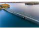 Breathtaking aerial view of the bridge spanning a deep blue lake with lush green islands at 6935 Melody Ridge Rd, Buford, GA 30518