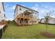 This backyard features lush grass and a large covered porch and patio at 6935 Melody Ridge Rd, Buford, GA 30518