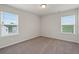 This bedroom features neutral paint, plush carpet, and large windows at 6935 Melody Ridge Rd, Buford, GA 30518