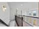 Hallway with wood and iron railings, carpeted floors, and large windows offering natural light at 6935 Melody Ridge Rd, Buford, GA 30518