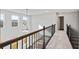 Open hallway with wood and iron railings, carpeted floors, and large windows offering natural light at 6935 Melody Ridge Rd, Buford, GA 30518