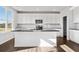 Modern kitchen with white cabinets, stainless steel appliances, and large island with sink at 6935 Melody Ridge Rd, Buford, GA 30518