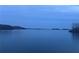Wide lake view, with a smooth surface reflecting the tranquil dusk sky and distant treeline at 6935 Melody Ridge Rd, Buford, GA 30518