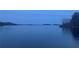 Still lake view with a smooth surface reflecting the serene sky and distant treeline at 6935 Melody Ridge Rd, Buford, GA 30518