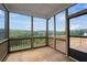 Enclosed back porch with wood flooring and screens, offering panoramic views of the surrounding trees at 6935 Melody Ridge Rd, Buford, GA 30518