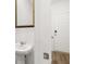 Powder room with pedestal sink and framed mirror near entry and stairs at 205 Kenoot Dr # 55, Mcdonough, GA 30253