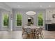 The dining area boasts bright windows, hardwood floors, stylish lighting, and seating for at least six people at 357 Mell Ne Ave, Atlanta, GA 30307