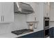 Close-up of a kitchen with gas range, custom backsplash and stainless steel hood at 357 Mell Ne Ave, Atlanta, GA 30307