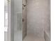 Walk-in shower featuring neutral stone tile, bench seating and glass door for a modern and sleek look at 357 Mell Ne Ave, Atlanta, GA 30307