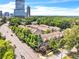 Aerial view of townhomes near a busy street, trees, and cityscape at 3676 Brookhaven Manor Ne Xing, Atlanta, GA 30319
