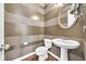Modern half-bathroom featuring hardwood floors, decorative striped wallpaper, and a stylish pedestal sink at 3676 Brookhaven Manor Ne Xing, Atlanta, GA 30319