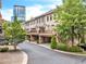 Brick townhome row showcases private balconies over driveways, with lush green trees, and city views at 3676 Brookhaven Manor Ne Xing, Atlanta, GA 30319