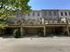Rear exterior view of townhomes with private garages and decks overlooking the parking area at 3676 Brookhaven Manor Ne Xing, Atlanta, GA 30319