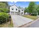 View of the exterior of a two-story home with an extra long driveway surrounded by mature trees and greenery at 4258 Anderson Ridge Way, Austell, GA 30106