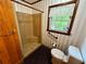 Bathroom featuring a neutral shower stall, toilet, and window with matching stripped wallpaper at 880 Havenridge Dr, Conyers, GA 30094