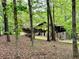 Exterior view of home through the trees, featuring a deck, stairs, and wooded surroundings, creating a secluded feel at 880 Havenridge Dr, Conyers, GA 30094