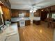 A well lit kitchen featuring wood cabinets, white appliances and countertops, and an open doorway into the living room at 880 Havenridge Dr, Conyers, GA 30094