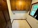 Laundry room with wood cabinets, tile floors, and a view of a window at 880 Havenridge Dr, Conyers, GA 30094