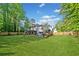 Large backyard with a well-maintained lawn, wooden fence, and an outdoor seating area at 2210 Spear Point Dr, Marietta, GA 30062