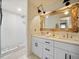 Luxurious bathroom with dual sinks, a decorative mirror, a subway tile shower, and updated fixtures at 2210 Spear Point Dr, Marietta, GA 30062