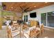 An outdoor covered patio with wood ceiling, ceiling fan, multiple seating areas, and an outdoor television at 2210 Spear Point Dr, Marietta, GA 30062