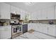 Well-lit kitchen with stainless steel appliances, white cabinets, and plenty of counter space at 2210 Spear Point Dr, Marietta, GA 30062